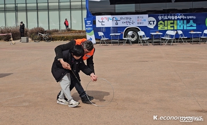 행사 진행을 돕고 있는 자원봉사자가 한 어린이에게 전통놀이인 굴렁쇠 굴리기를 가르쳐주고 있는 모습 <강소하 기자> 